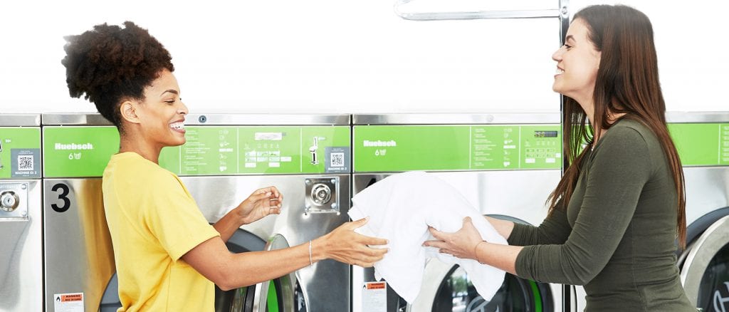 Illustration: people smiling in a laundromat - Prepare a sound laundry business plan